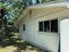 Exterior of a home features a window and lush surrounding foliage, adding natural charm at 7601 Pine Hill Dr, Tampa, FL 33617