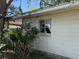 Home's exterior features durable siding, a functional window, and lush surrounding foliage at 7601 Pine Hill Dr, Tampa, FL 33617