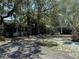 Charming single-story home featuring mature landscaping, a covered carport, and a long paved driveway at 7601 Pine Hill Dr, Tampa, FL 33617