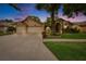 Exterior of a single-story home at dusk with a three-car garage and landscaped yard at 905 Balsamina Dr, Brandon, FL 33510