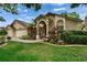 Single-story home featuring an arched entryway, well-maintained landscaping, and a three-car garage at 905 Balsamina Dr, Brandon, FL 33510