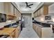 Well-lit galley kitchen featuring wood cabinets, granite counters, and views into living spaces at 905 Balsamina Dr, Brandon, FL 33510