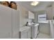 Functional laundry room with modern washer/dryer units, storage cabinets, and a window for natural light at 905 Balsamina Dr, Brandon, FL 33510