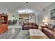 Bright living room with open floor plan featuring wood-look floors, comfortable seating, and views to kitchen and dining at 905 Balsamina Dr, Brandon, FL 33510