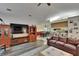 Spacious living room with wood-look floors, leather sofa, media center, and views to the dining area and kitchen at 905 Balsamina Dr, Brandon, FL 33510