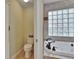 Bright bathroom with soaking tub, glass block window and toilet to the left at 905 Balsamina Dr, Brandon, FL 33510