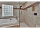 Close-up of bathtub and shower with glass enclosure and tiled walls and floors at 905 Balsamina Dr, Brandon, FL 33510
