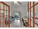 Bright office space with wood floors, glass doors, and a view of the screened-in patio at 905 Balsamina Dr, Brandon, FL 33510