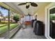 Relaxing screened patio with ceiling fans, outdoor seating, and barbecue grills overlooking the backyard at 905 Balsamina Dr, Brandon, FL 33510