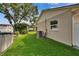 Landscaped yard featuring well-maintained lawn, white fencing, and mature shade trees at 905 Balsamina Dr, Brandon, FL 33510