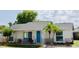 Charming single-story home boasts a bright blue front door, lush landscaping, and a welcoming front porch with seating at 9128 Suffield Ct, Tampa, FL 33615