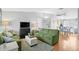 Inviting living room featuring hardwood floors, comfortable green sofas, and a ceiling fan at 9128 Suffield Ct, Tampa, FL 33615