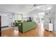 Bright living room featuring hardwood floors, green sofas, a ceiling fan, and ample natural light at 9128 Suffield Ct, Tampa, FL 33615