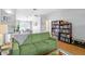 Spacious living room with hardwood floors, a cozy green sofa, and well-stocked bookshelves at 9128 Suffield Ct, Tampa, FL 33615