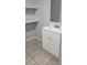 Bathroom featuring a white vanity with a white countertop and open shelving at 9307 N 16Th St, Tampa, FL 33612