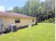 The backyard features lush green grass, mature trees, and a well-maintained exterior at 7535 Cypress Knoll Dr, New Port Richey, FL 34653
