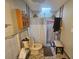 Bathroom with a shower, toilet, medicine cabinet and bench in need of repairs at 7535 Cypress Knoll Dr, New Port Richey, FL 34653