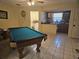 An airy game room featuring a pool table and a glimpse of the kitchen and laundry area at 7535 Cypress Knoll Dr, New Port Richey, FL 34653