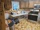 An additional kitchen area featuring a stainless steel oven, wooden cabinets and brown tile flooring at 7535 Cypress Knoll Dr, New Port Richey, FL 34653
