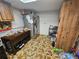 An additional kitchen area featuring a refrigerator, wooden cabinets and brown tile flooring at 7535 Cypress Knoll Dr, New Port Richey, FL 34653