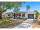 Charming single-story home featuring a well-manicured lawn and a classic neutral color scheme with black window trim at 3300 52Nd N St, St Petersburg, FL 33710