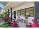 Inviting front porch with seating and lush landscaping featuring vibrant plants and flowers at 3300 52Nd N St, St Petersburg, FL 33710