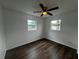 Well-lit bedroom with modern ceiling fan, new flooring, and dual windows at 103 Inwood Cir, Brandon, FL 33510