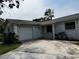 Single-story home featuring attached garage, lush landscaping, and a well-maintained front yard at 103 Inwood Cir, Brandon, FL 33510