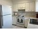 Well-maintained kitchen featuring white appliances, ample counter space, and classic white cabinetry at 103 Inwood Cir, Brandon, FL 33510