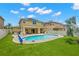 Inviting backyard with a sparkling pool, covered patio, and manicured artificial grass at 10596 Lake Seminole Ter, Seminole, FL 33772
