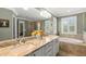 Bright bathroom with a double vanity, soaking tub, and glass-enclosed shower at 10596 Lake Seminole Ter, Seminole, FL 33772