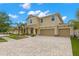 Two-story home with a three-car garage, neutral paint, paver driveway and manicured landscaping at 10596 Lake Seminole Ter, Seminole, FL 33772