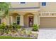 Inviting front porch with decorative columns, beautiful front door and colorful landscaping at 10596 Lake Seminole Ter, Seminole, FL 33772