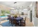 Eat-in kitchen featuring white cabinets, stainless appliances, mosaic tile backsplash, and view of the pool at 10596 Lake Seminole Ter, Seminole, FL 33772