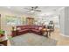 Comfortable living room with red couch, blue rug, and view into the bright and airy kitchen at 10596 Lake Seminole Ter, Seminole, FL 33772