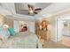 Elegant main bedroom with a tray ceiling, neutral walls, and a view into the en-suite bathroom at 10596 Lake Seminole Ter, Seminole, FL 33772
