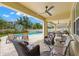 Spacious covered patio featuring comfortable seating and a lovely view of the backyard pool at 10596 Lake Seminole Ter, Seminole, FL 33772