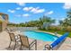 Inviting backyard features an in-ground pool, lounge chairs, artificial turf, and perimeter fence at 10596 Lake Seminole Ter, Seminole, FL 33772