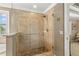 Modern shower with stone tiles, glass enclosure, and convenient grab bar at 10596 Lake Seminole Ter, Seminole, FL 33772