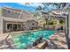 Screened-in pool with decorative dragon statue, poolside seating and an outdoor fan, creating a tranquil oasis at 1120 43Rd N Ave, St Petersburg, FL 33703
