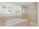 A luxurious bathroom featuring a soaking tub and a glass-enclosed shower with decorative tiles at 1122 Shipwatch Cir, Tampa, FL 33602