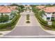 Beautifully landscaped community entrance with lush plantings, mature palms, and red tile roofs at 1122 Shipwatch Cir, Tampa, FL 33602