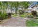 Wide view of landscaped courtyard featuring brick pathways, lush trees, and manicured bushes, creating a scenic community space at 1122 Shipwatch Cir, Tampa, FL 33602