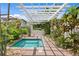 Covered hot tub area featuring a stone surround, tiled interior, and lush landscaping creating a relaxing oasis at 1122 Shipwatch Cir, Tampa, FL 33602