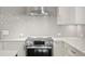 Close-up of stainless steel range with range hood and white cabinets at 1122 Shipwatch Cir, Tampa, FL 33602