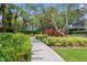 Pathway through lush landscaping with tropical plants, flowers, and shade trees at 1122 Shipwatch Cir, Tampa, FL 33602