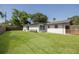 Wide shot of backyard with fence, grass and view of the rear exterior of the home at 11296 115Th St, Largo, FL 33778