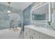 Luxurious bathroom featuring blue marble accent wall, soaking tub, and modern vanity with stylish lighting at 11296 115Th St, Largo, FL 33778