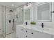 Beautiful bathroom featuring a double sink vanity, a modern shower with glass door and sleek black fixtures at 11296 115Th St, Largo, FL 33778