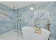 Spa-like bathroom showcasing blue marble shower and soaking tub, complemented by sleek fixtures and modern lighting at 11296 115Th St, Largo, FL 33778